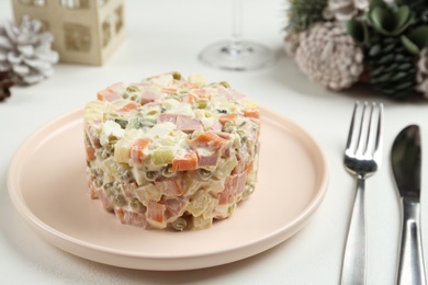 Traditional russian salad Olivier served on white table Photo of Traditional russian salad Olivier served on white table