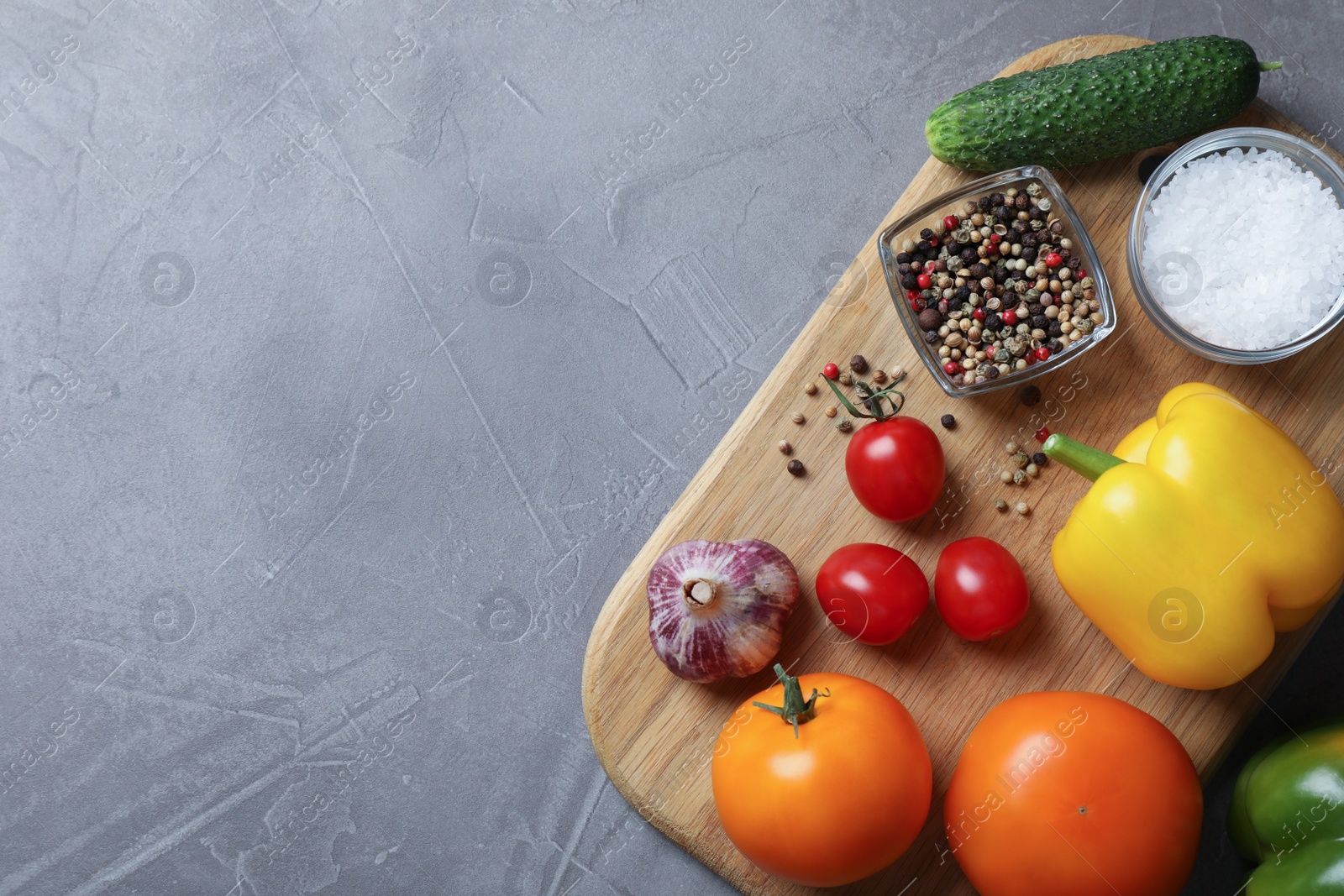 Different vegetables and seasonings on grey table, top view. Space for text Photo of Different vegetables and seasonings on grey table, top view. Space for text