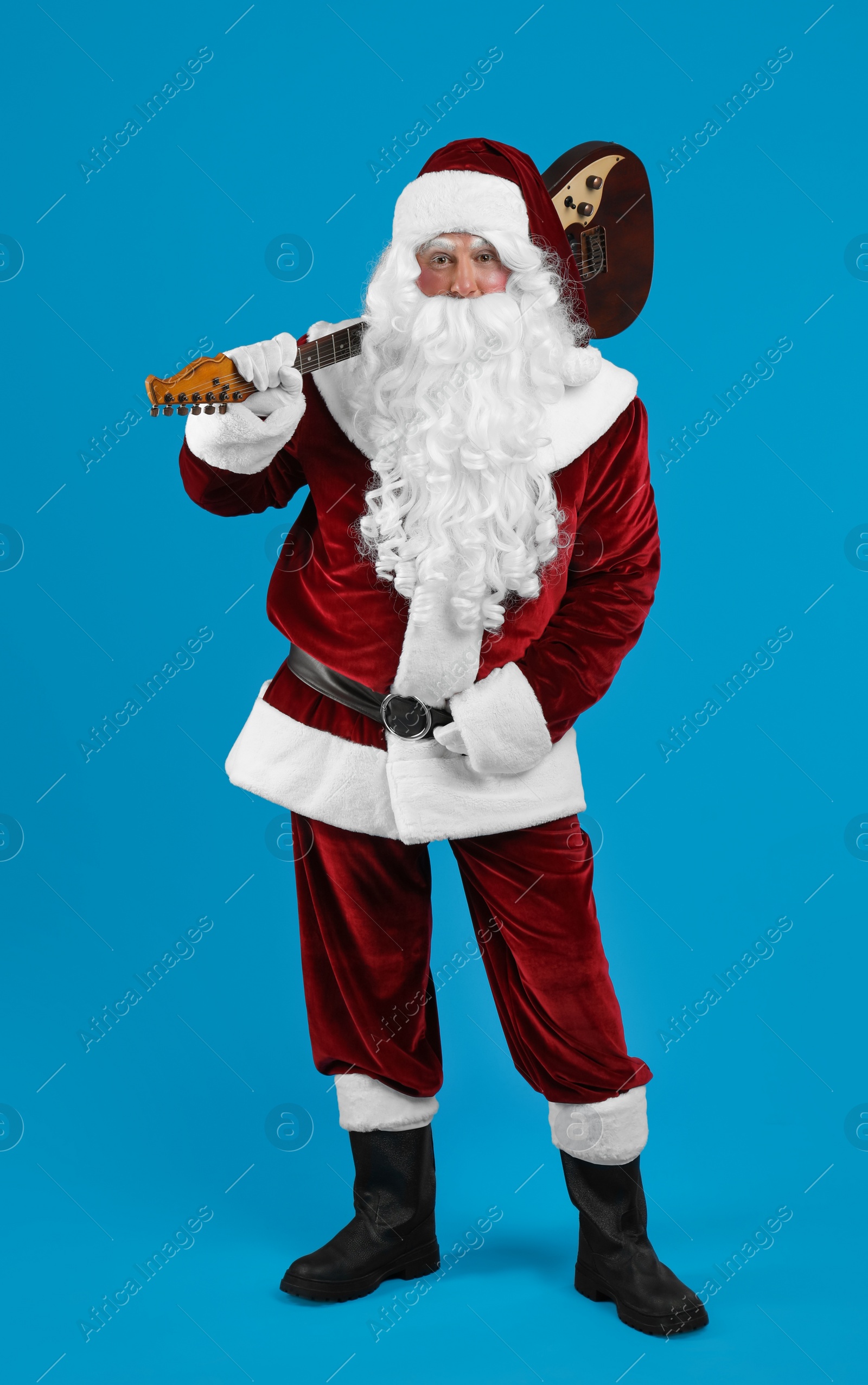Santa Claus with electric guitar on blue background. Christmas music Photo of Santa Claus with electric guitar on blue background. Christmas music
