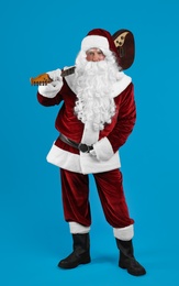 Santa Claus with electric guitar on blue background. Christmas music Photo of Santa Claus with electric guitar on blue background. Christmas music