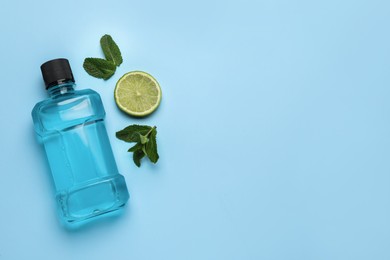 Mouthwash, mint and lime on light blue background, flat lay. Space for text Photo of Mouthwash, mint and lime on light blue background, flat lay. Space for text
