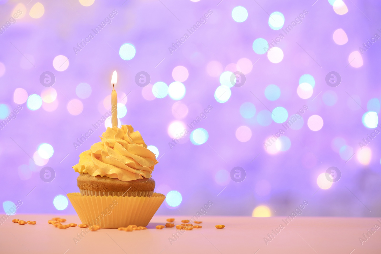 Birthday cupcake with candle against blurred lights Photo of Birthday cupcake with candle against blurred lights