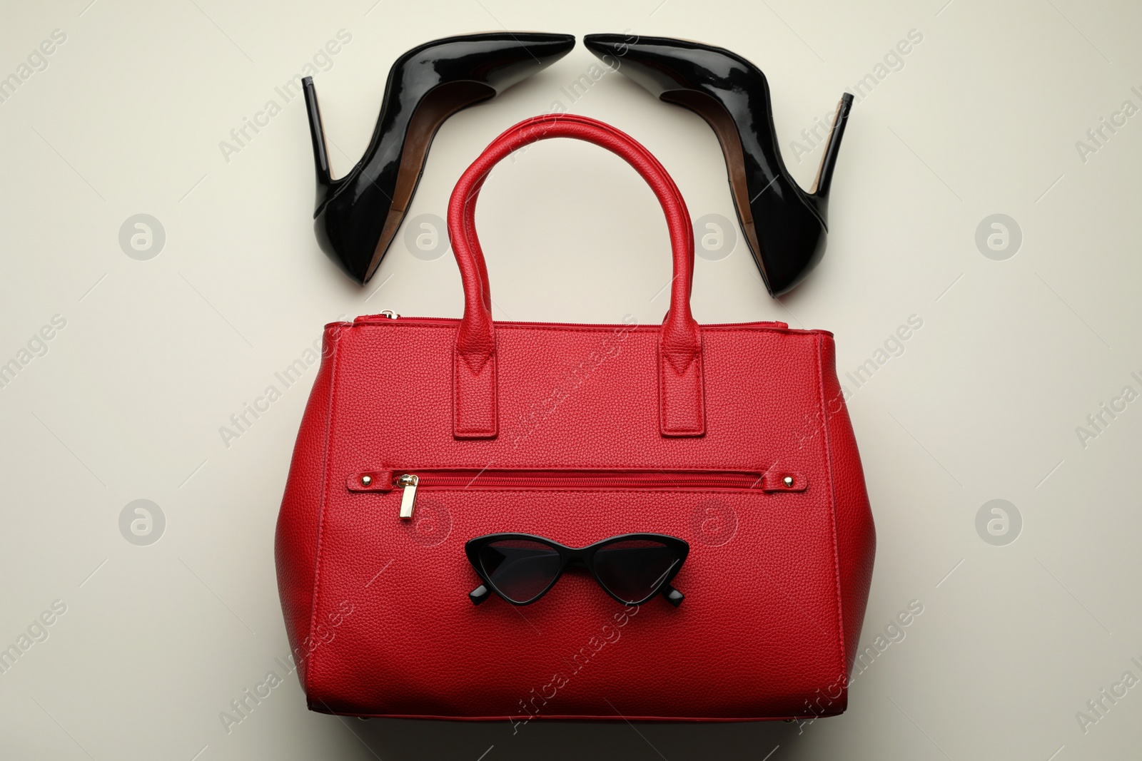 Stylish woman's bag, sunglasses and shoes on light background, flat lay Photo of Stylish woman's bag, sunglasses and shoes on light background, flat lay