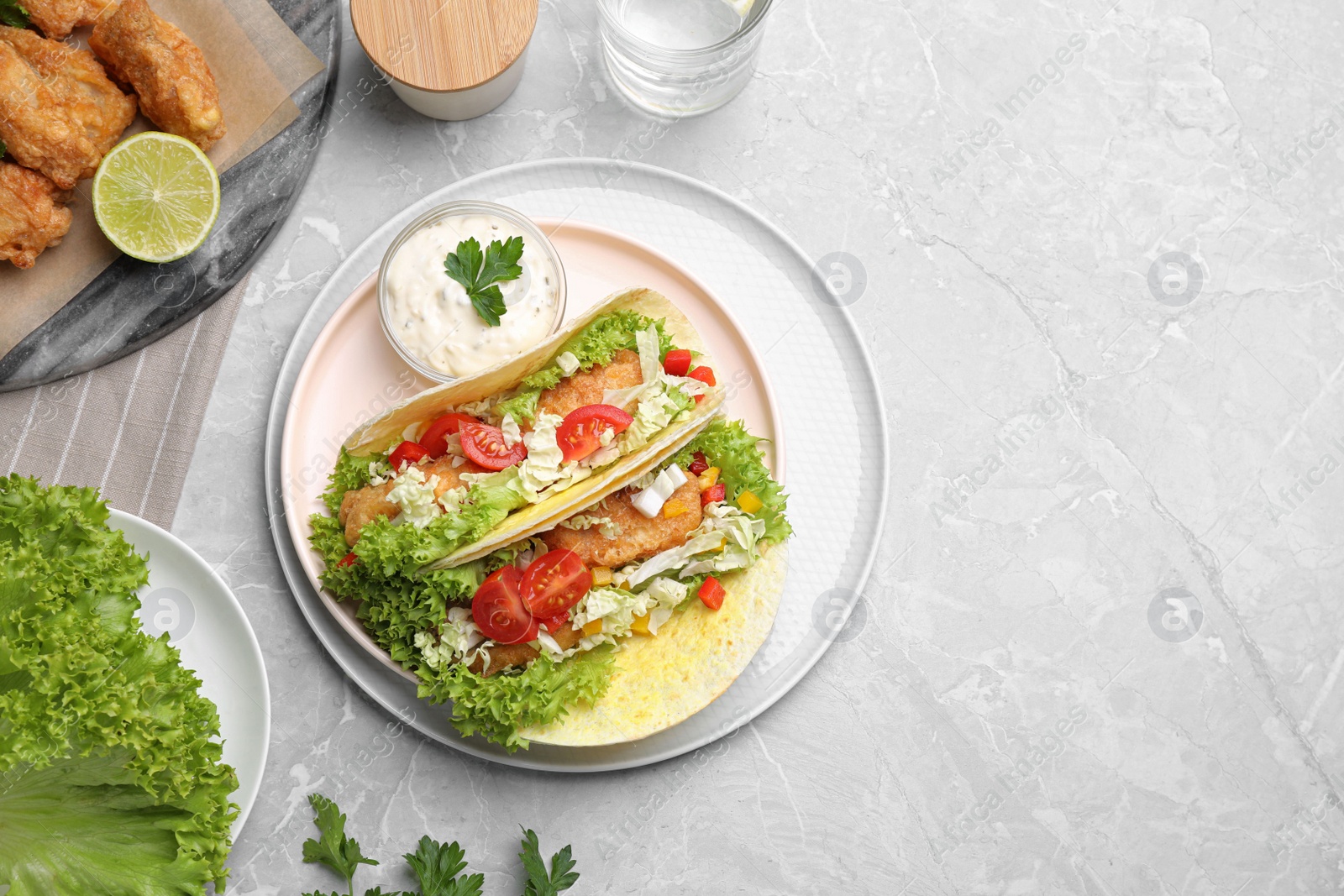 Delicious fish tacos served on grey marble table, flat lay with space for text Photo of Delicious fish tacos served on grey marble table, flat lay with space for text