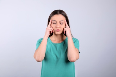 Portrait of stressed young woman on light background Photo of Portrait of stressed young woman on light background