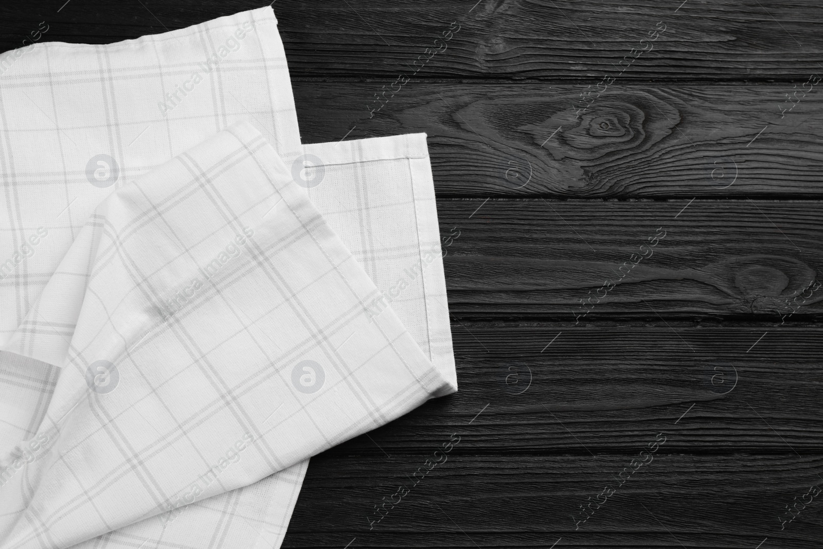 Kitchen towel on black wooden table, top view. Space for text Photo of Kitchen towel on black wooden table, top view. Space for text