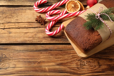 Delicious gingerbread cake, candy canes and Christmas decor on wooden table, above view. Space for text Photo of Delicious gingerbread cake, candy canes and Christmas decor on wooden table, above view. Space for text