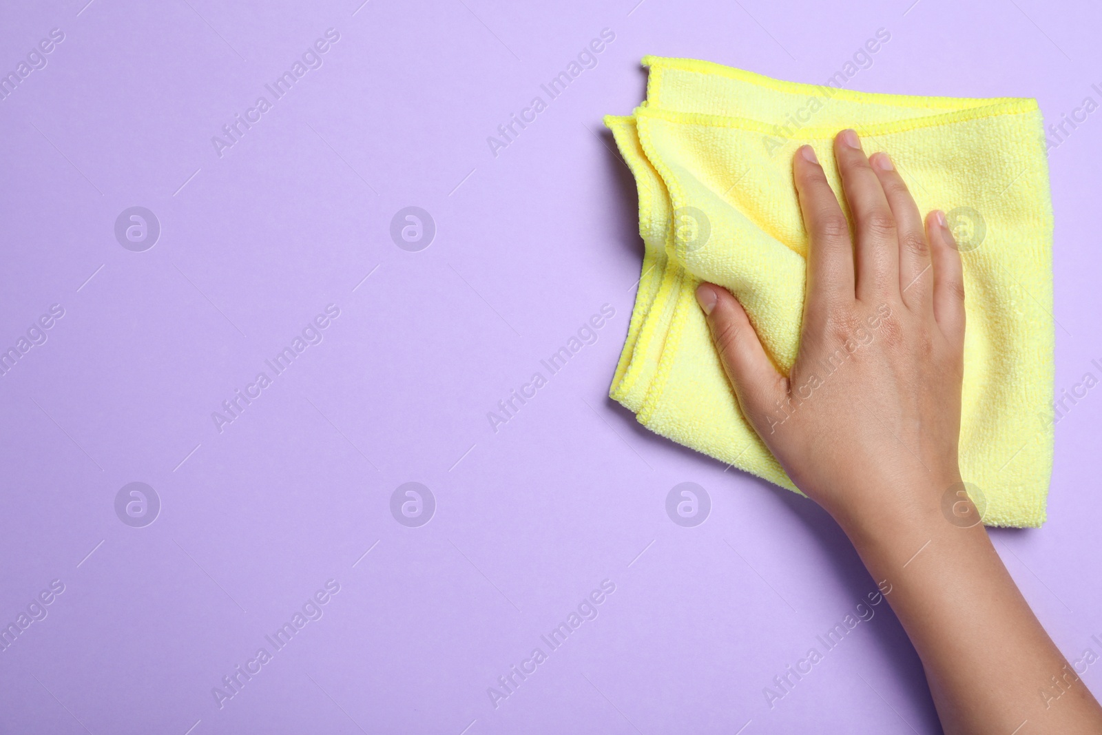 Woman with microfiber cloth on light background, top view. Space for text Photo of Woman with microfiber cloth on light background, top view. Space for text