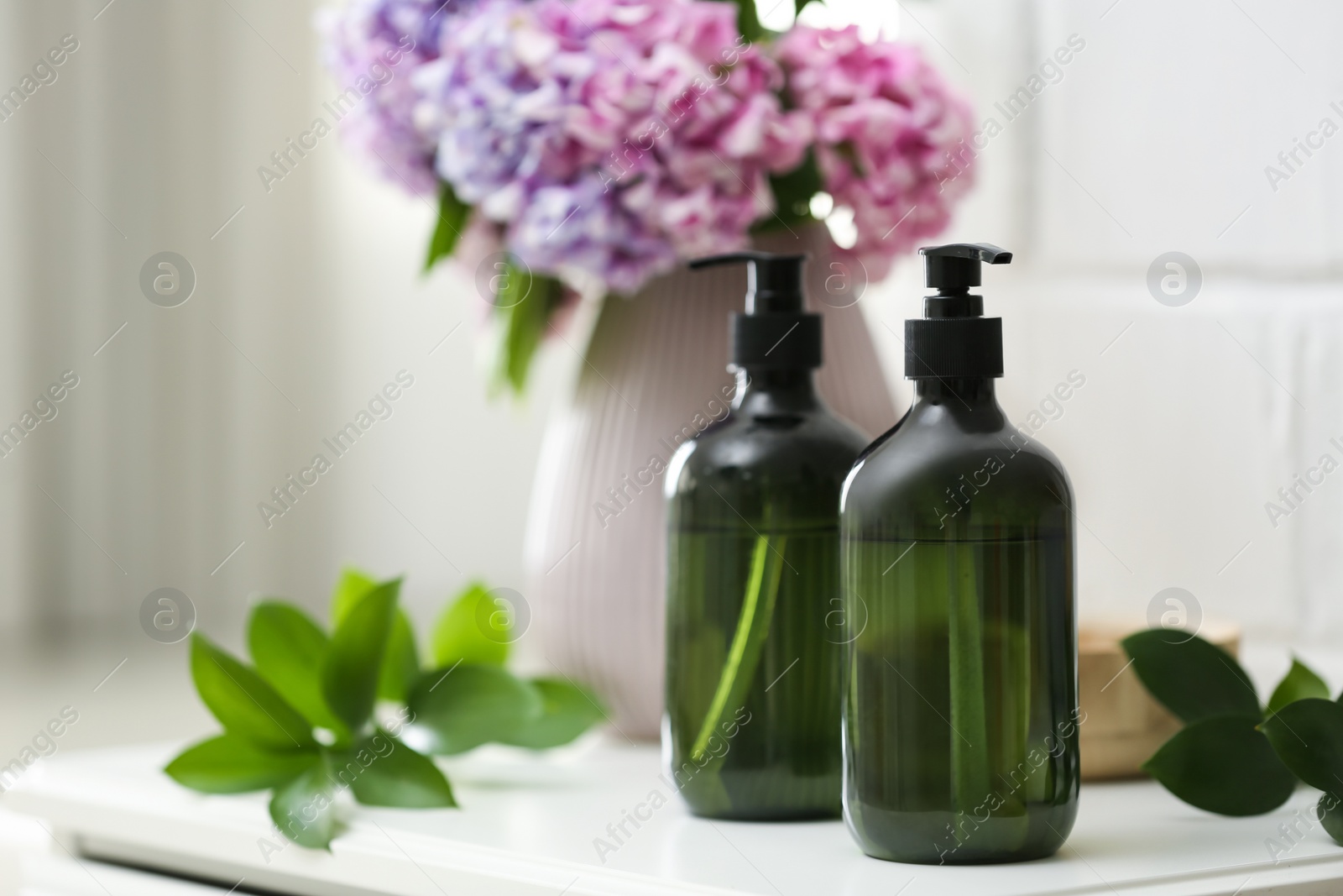 Soap dispensers and beautiful bouquet on table. Space for text Photo of Soap dispensers and beautiful bouquet on table. Space for text