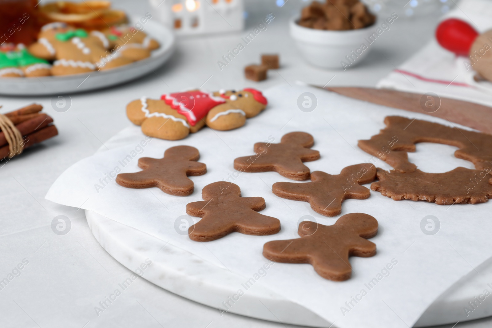 Making homemade Christmas cookies. Dough for gingerbread man and cutter on white table Photo of Making homemade Christmas cookies. Dough for gingerbread man and cutter on white table