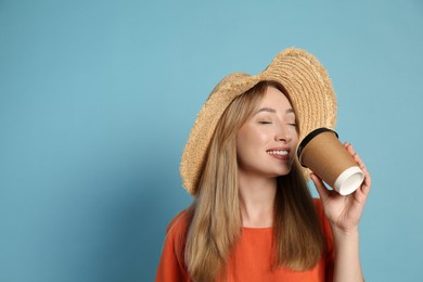 Beautiful young woman with straw hat drinking coffee from paper cup on light blue background, space for text. Stylish headdress Photo of Beautiful young woman with straw hat drinking coffee from paper cup on light blue background, space for text. Stylish headdress