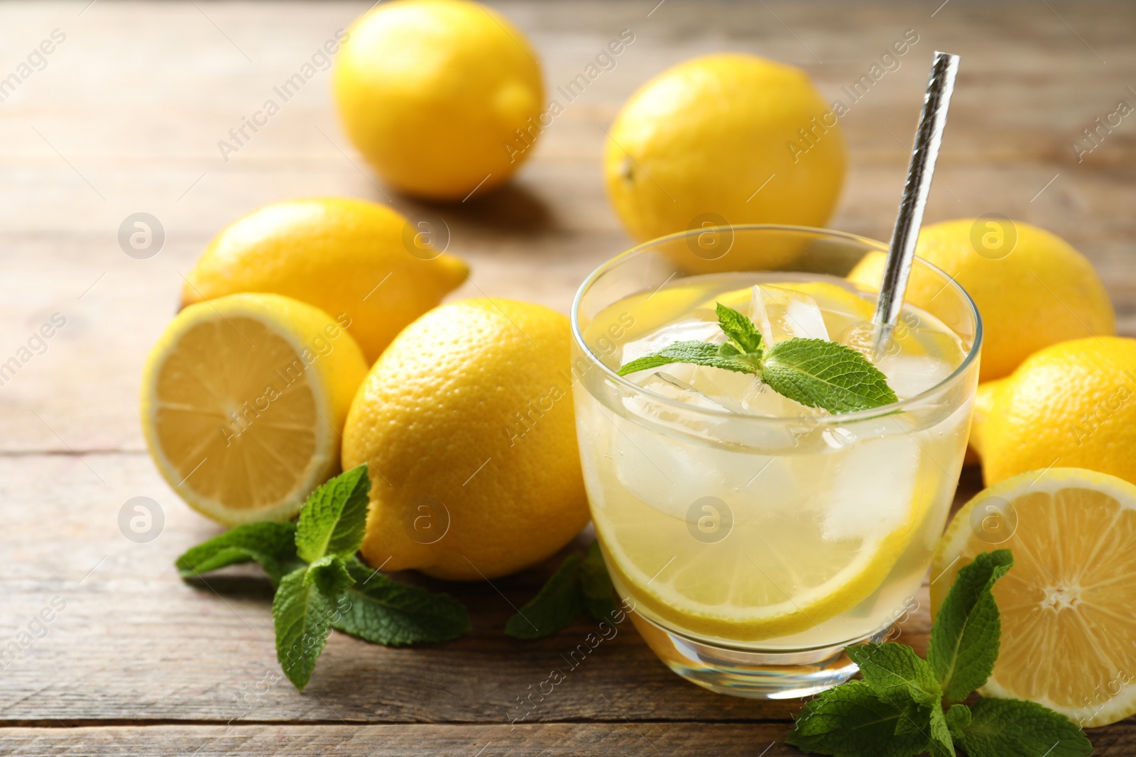 Natural lemonade with mint and fresh fruits on wooden table, closeup. Summer refreshing drink Photo of Natural lemonade with mint and fresh fruits on wooden table, closeup. Summer refreshing drink