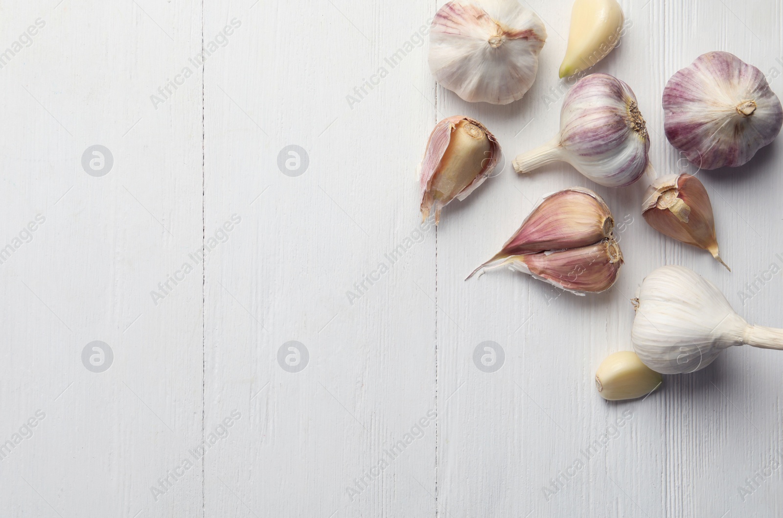 Fresh organic garlic on white wooden table, flat lay. Space for text Photo of Fresh organic garlic on white wooden table, flat lay. Space for text
