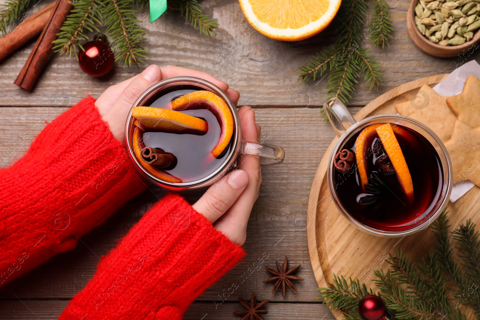Woman with cup of mulled wine at wooden table, top view Photo of Woman with cup of mulled wine at wooden table, top view