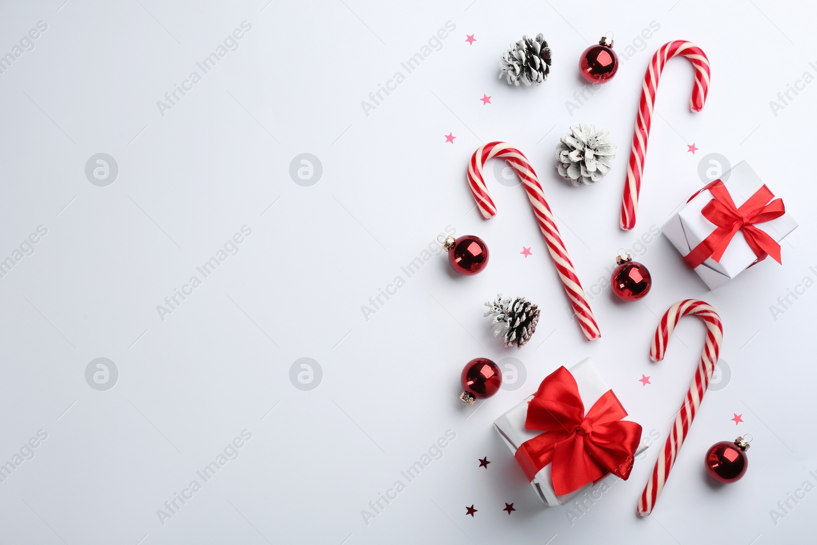 Flat lay composition with candy canes and Christmas decor on white background. Space for text Photo of Flat lay composition with candy canes and Christmas decor on white background. Space for text