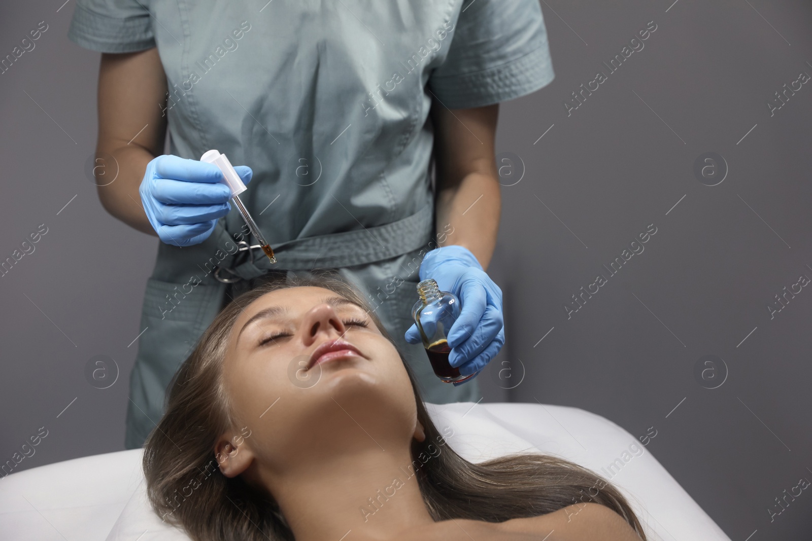 Cosmetologist applying serum on client's face in salon Photo of Cosmetologist applying serum on client's face in salon