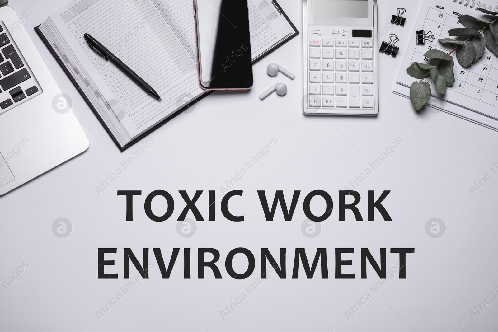 Laptop, smartphone, stationery and text TOXIC WORK ENVIRONMENT on white background, flat lay. Space for text Image of Laptop, smartphone, stationery and text TOXIC WORK ENVIRONMENT on white background, flat lay. Space for text