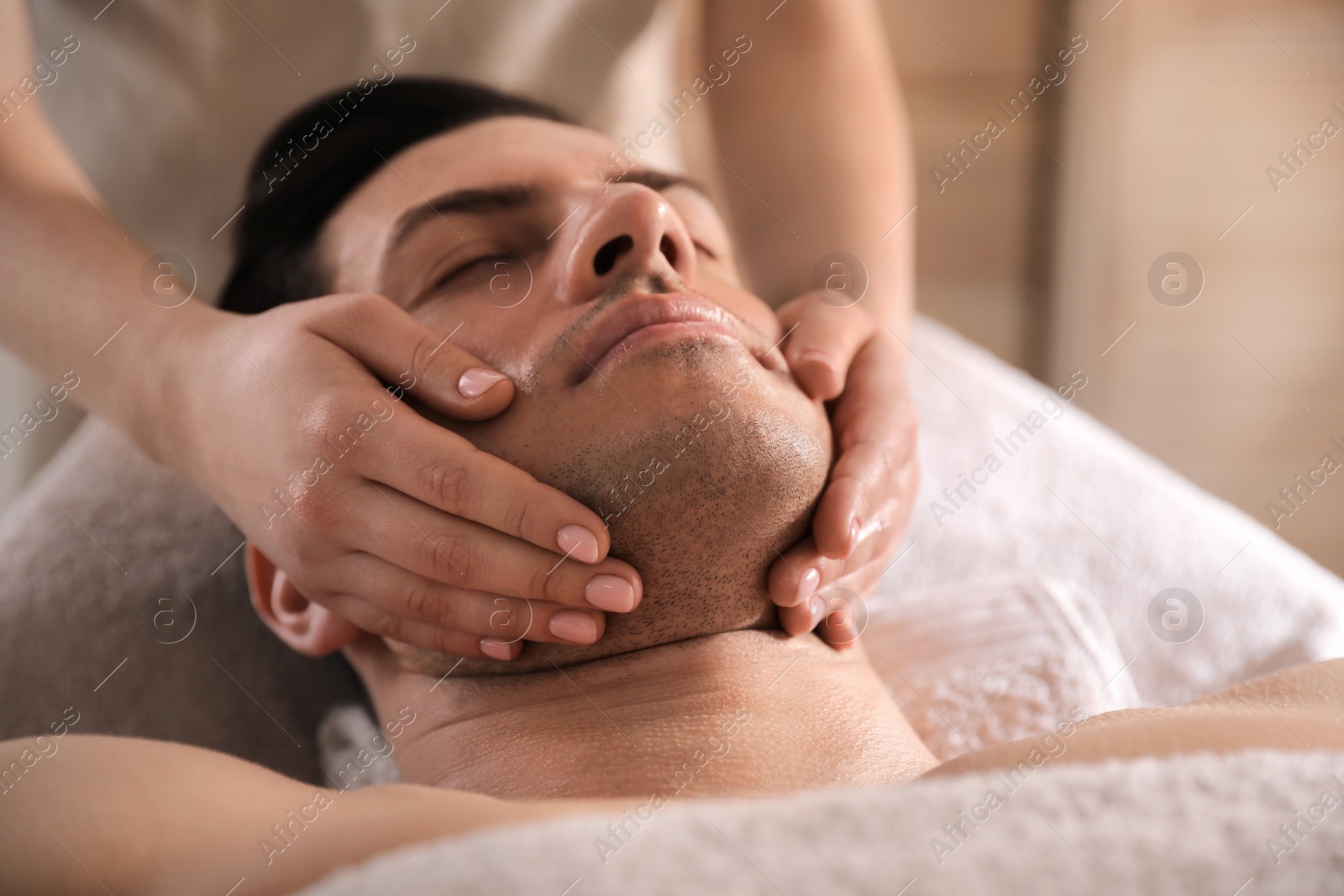 Man receiving facial massage in beauty salon, closeup Photo of Man receiving facial massage in beauty salon, closeup