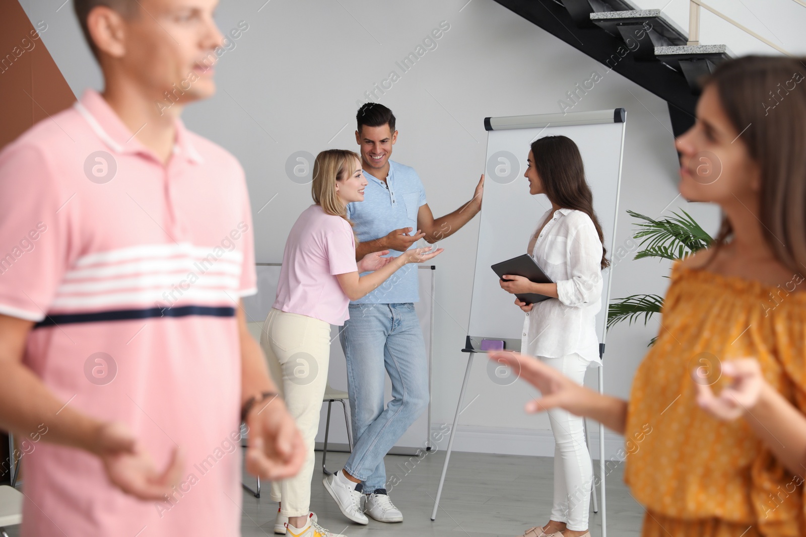 Group of people talking near whiteboard in hall Photo of Group of people talking near whiteboard in hall