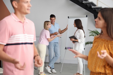 Group of people talking near whiteboard in hall Photo of Group of people talking near whiteboard in hall