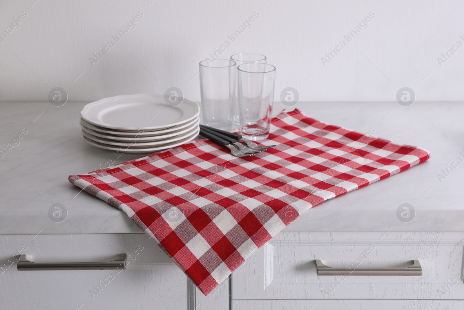 Dry kitchen towel and clean dishware on white marble countertop Photo of Dry kitchen towel and clean dishware on white marble countertop