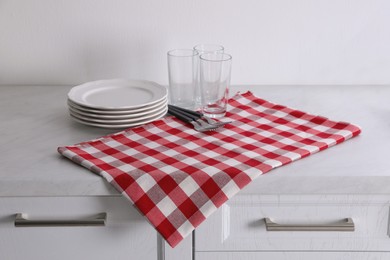 Dry kitchen towel and clean dishware on white marble countertop Photo of Dry kitchen towel and clean dishware on white marble countertop