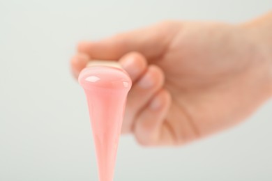 Woman holding spatula with hot depilatory wax on light background, closeup Photo of Woman holding spatula with hot depilatory wax on light background, closeup