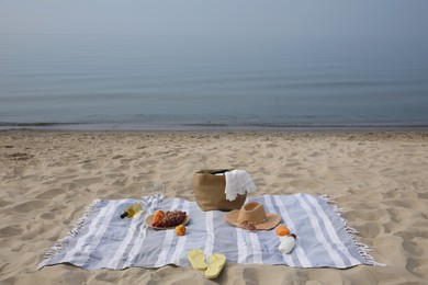 Bag, blanket, wine and other stuff for beach picnic on sandy seashore Photo of Bag, blanket, wine and other stuff for beach picnic on sandy seashore