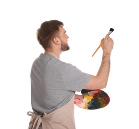Man painting with brush on white background. Young artist Photo of Man painting with brush on white background. Young artist