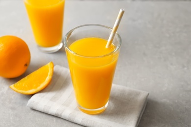 Glasses of orange juice and fresh fruits on light background Photo of Glasses of orange juice and fresh fruits on light background