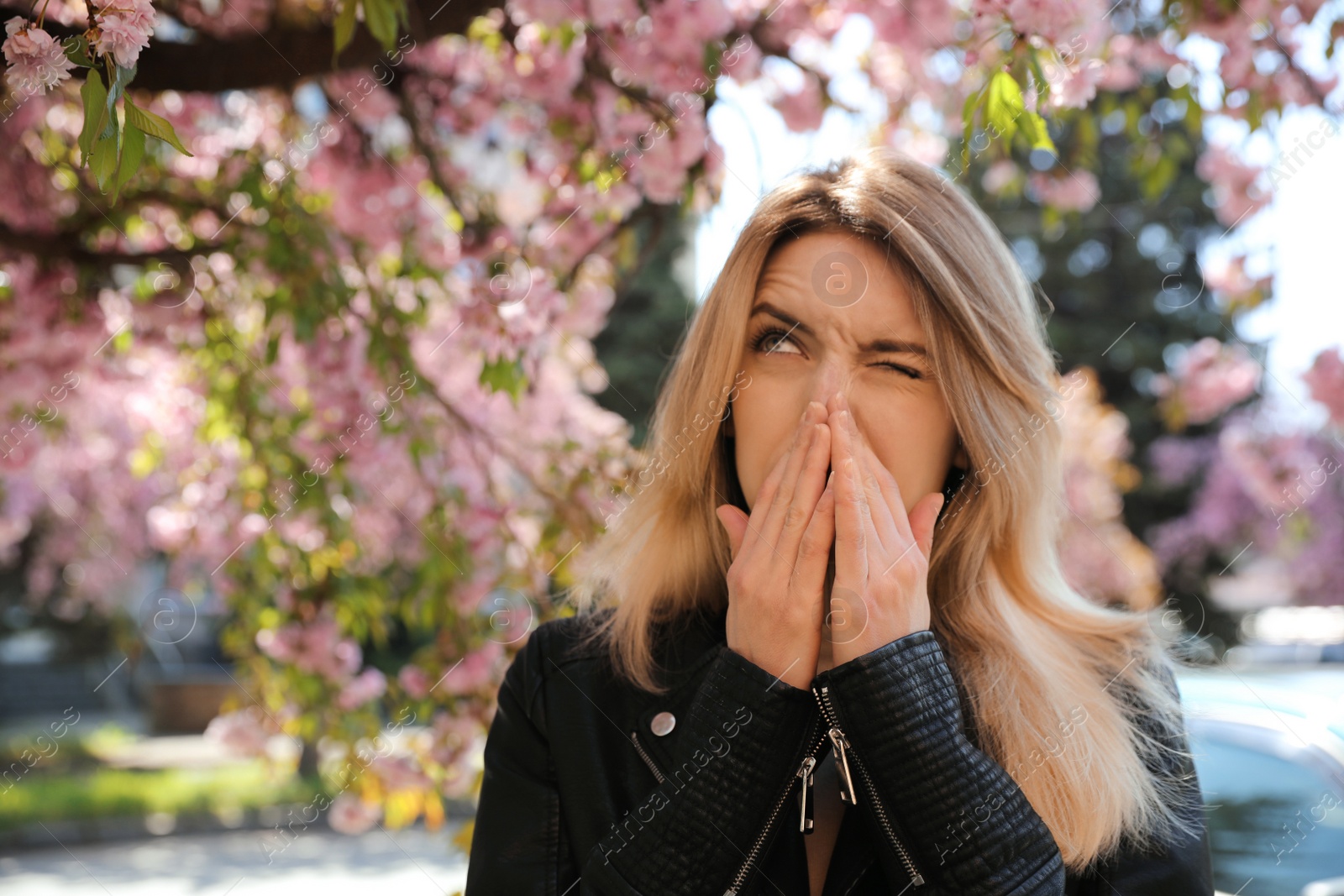 Woman suffering from seasonal pollen allergy near blossoming tree outdoors Photo of Woman suffering from seasonal pollen allergy near blossoming tree outdoors