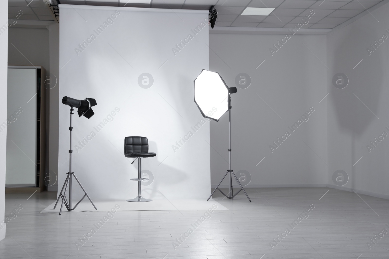Photo studio interior with modern chair and professional lighting equipment Photo of Photo studio interior with modern chair and professional lighting equipment
