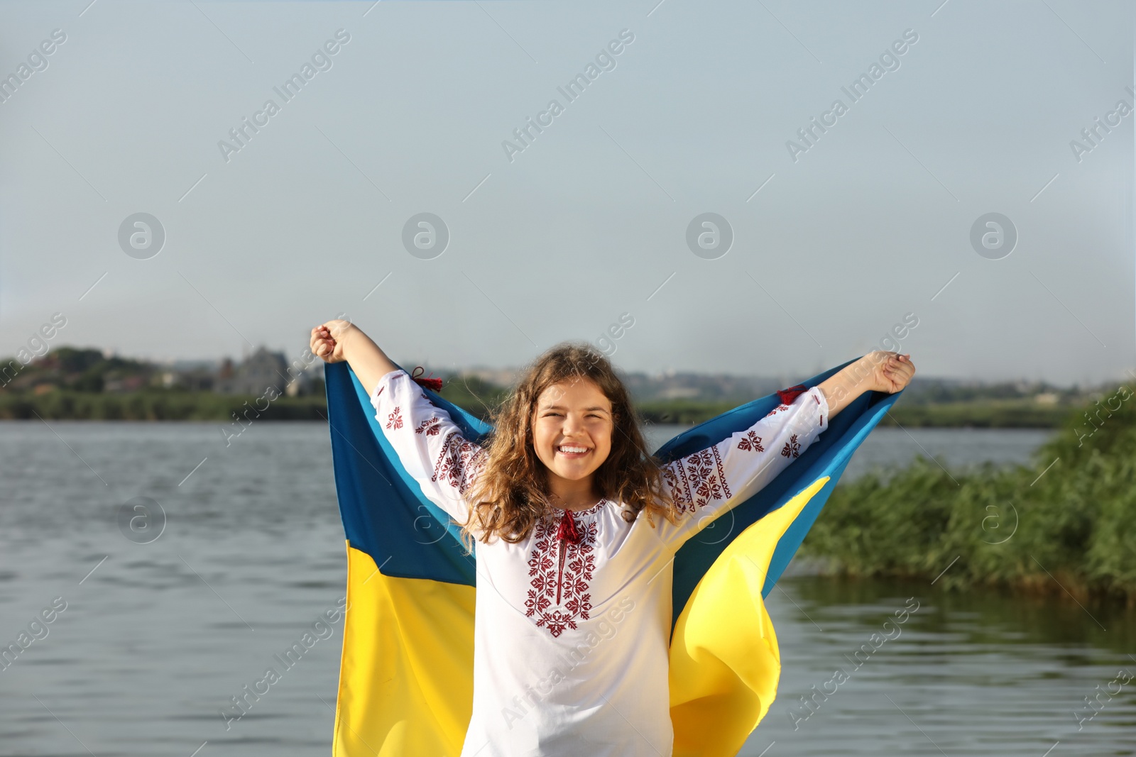 Teenage girl in vyshyvanka with flag of Ukraine outdoors Photo of Teenage girl in vyshyvanka with flag of Ukraine outdoors
