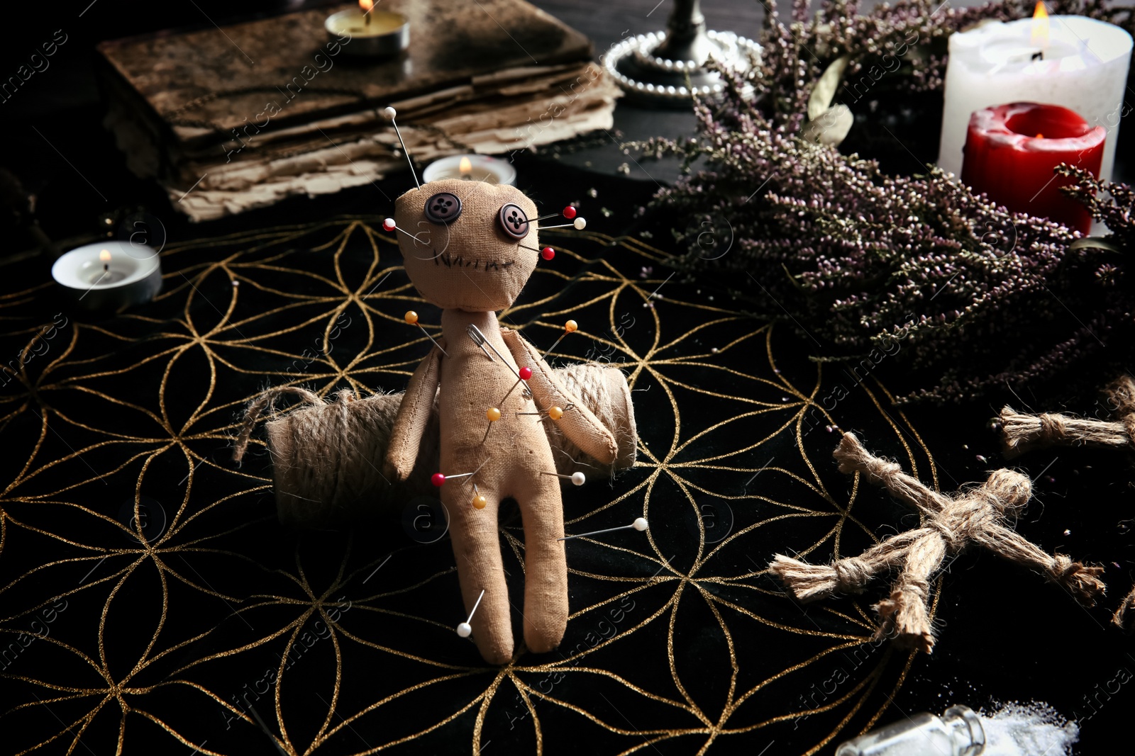 Voodoo doll pierced with pins on table. Curse ceremony Photo of Voodoo doll pierced with pins on table. Curse ceremony