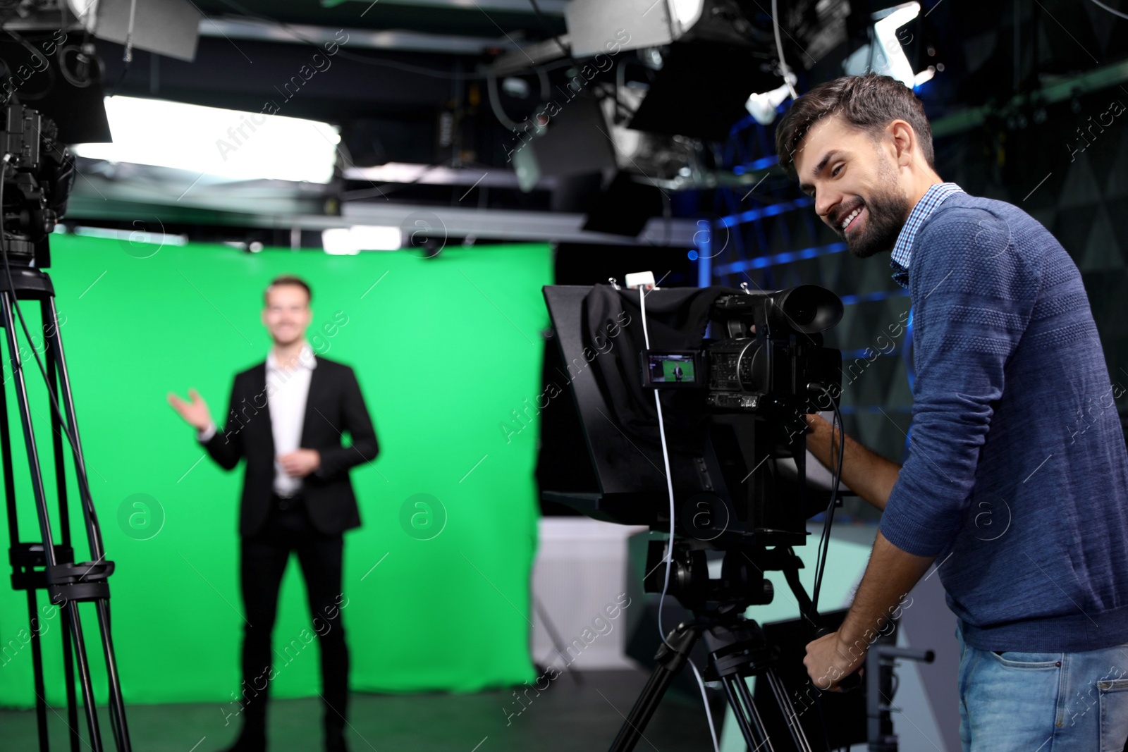 Presenter and video camera operator working in studio. News broadcasting Photo of Presenter and video camera operator working in studio. News broadcasting