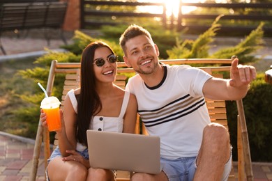 Happy couple with laptop resting together outdoors Image of Happy couple with laptop resting together outdoors