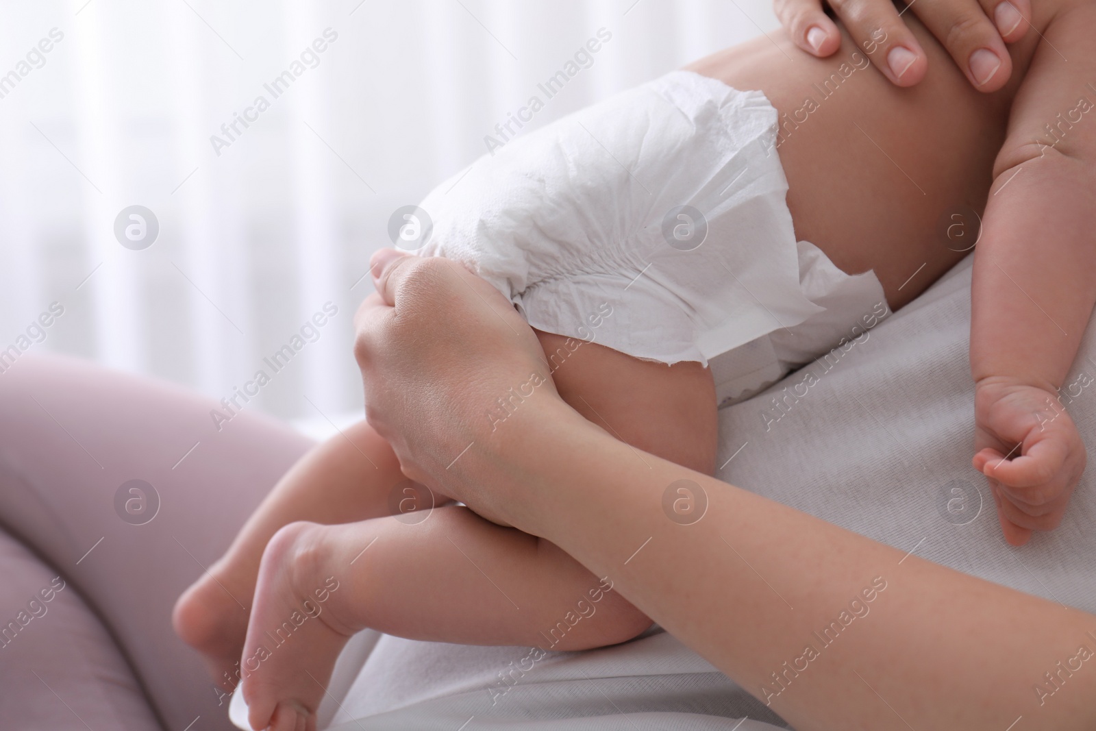 Mom holding her baby in diaper at home, closeup Photo of Mom holding her baby in diaper at home, closeup