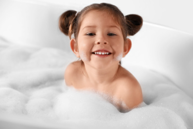 Cute little girl taking bubble bath at home Photo of Cute little girl taking bubble bath at home