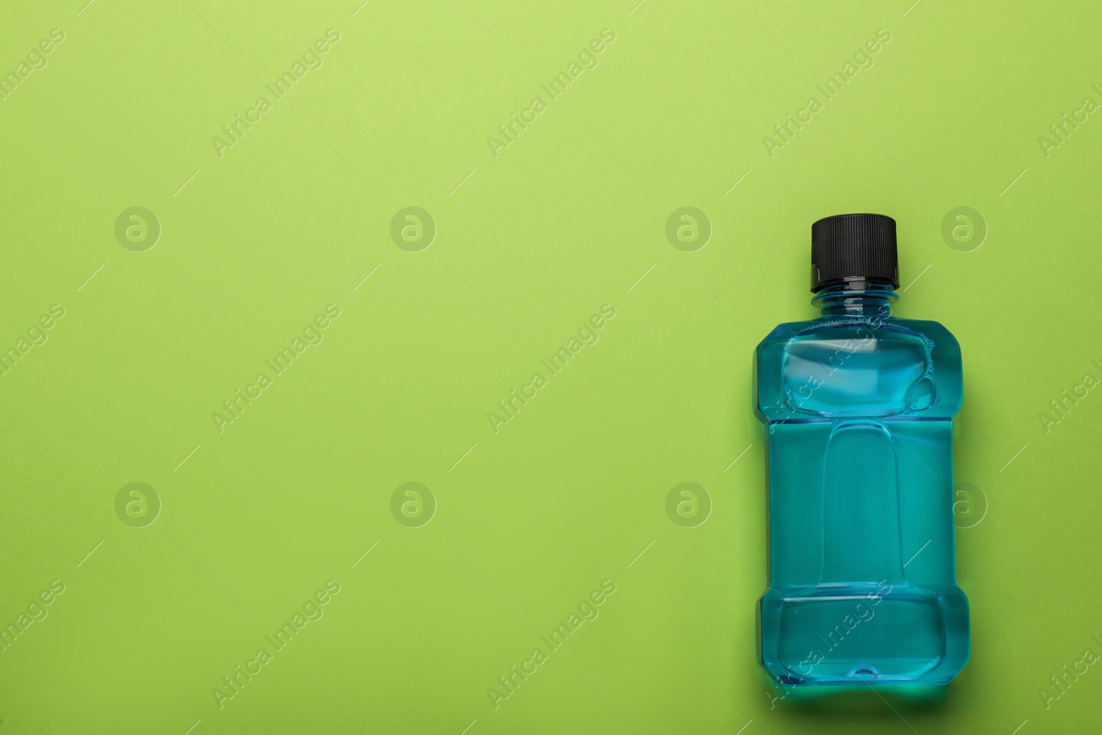 Mouthwash on light green background, top view. Space for text Photo of Mouthwash on light green background, top view. Space for text