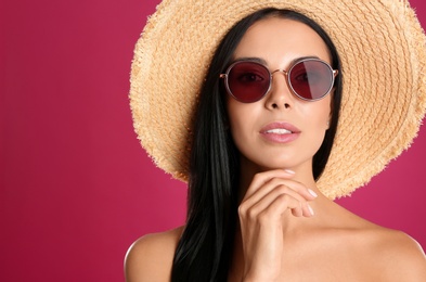 Beautiful woman wearing sunglasses on pink background Photo of Beautiful woman wearing sunglasses on pink background