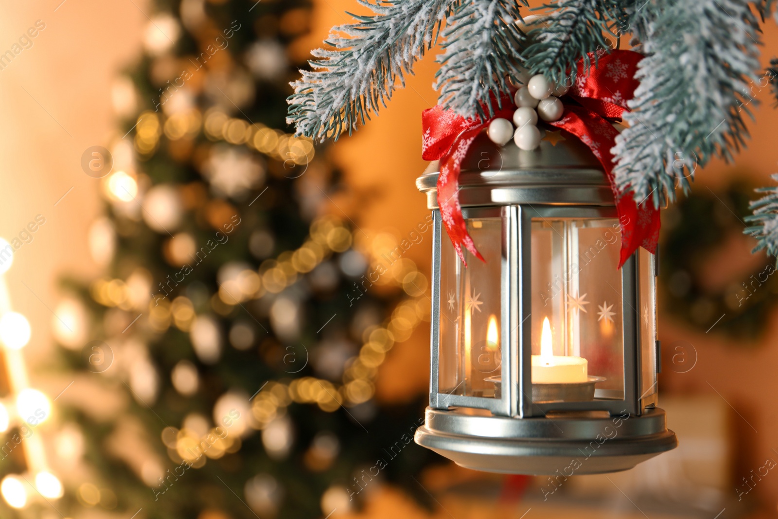 Vintage Christmas lantern with burning candle hanging on fir branch against blurred background. Space for text Photo of Vintage Christmas lantern with burning candle hanging on fir branch against blurred background. Space for text