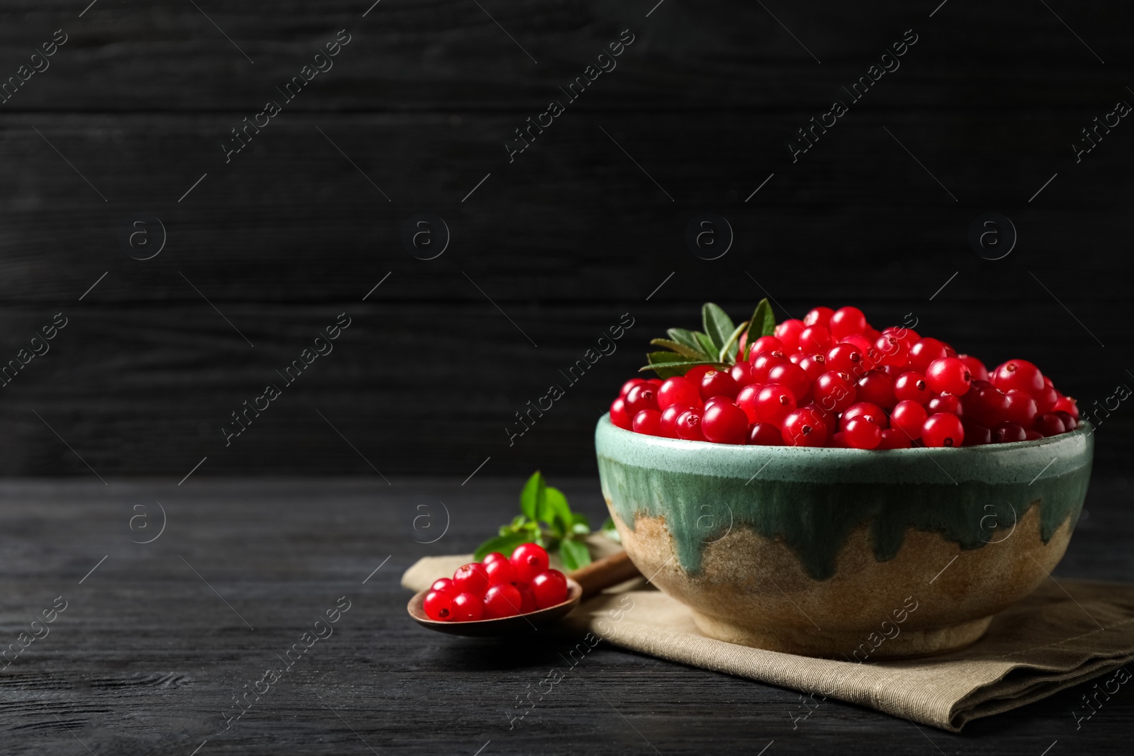 Tasty ripe cranberries on black wooden table. Space for text Photo of Tasty ripe cranberries on black wooden table. Space for text