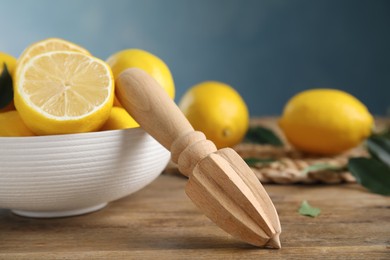 Squeezer with lemons on wooden table, closeup Photo of Squeezer with lemons on wooden table, closeup