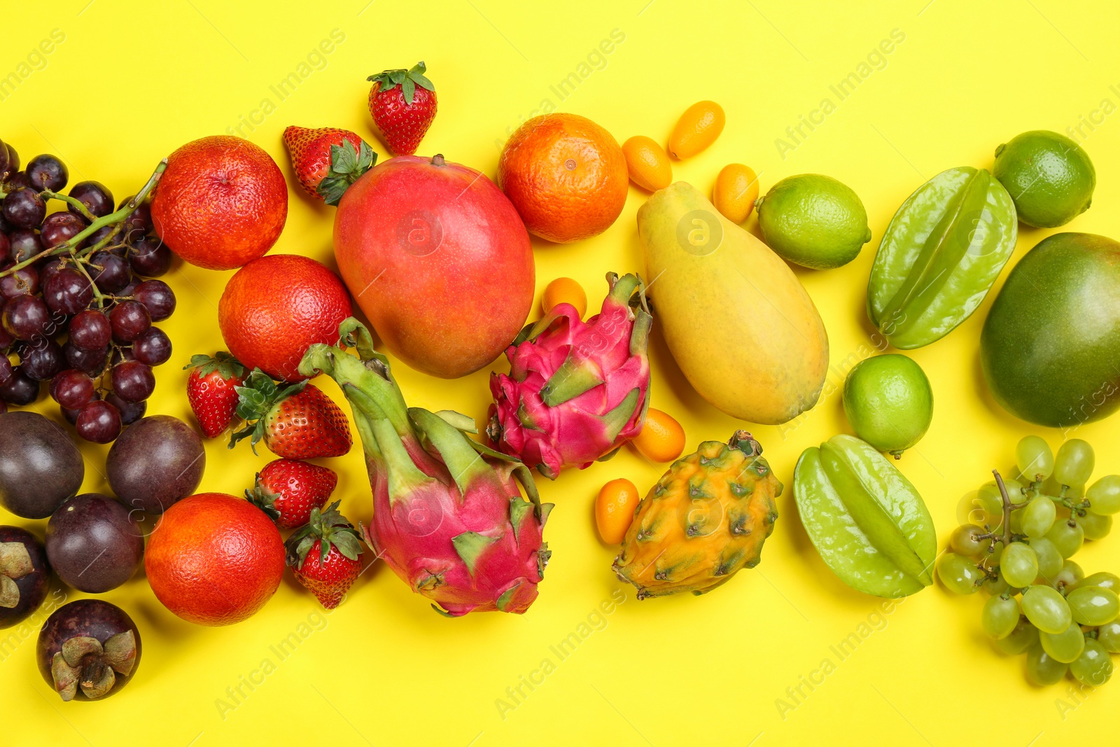Photo of Assortment of fresh exotic fruits on yellow background, flat lay