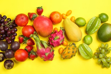 Assortment of fresh exotic fruits on yellow background, flat lay Photo of Assortment of fresh exotic fruits on yellow background, flat lay