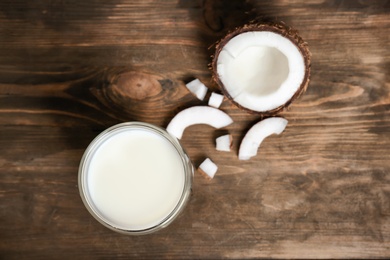 Glass of coconut milk and fresh nut on wooden background, top view Photo of Glass of coconut milk and fresh nut on wooden background, top view
