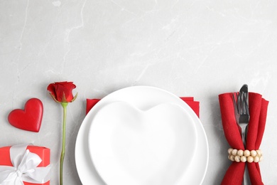 Romantic table setting on light grey background, flat lay with space for text. Valentine's day celebration Photo of Romantic table setting on light grey background, flat lay with space for text. Valentine's day celebration