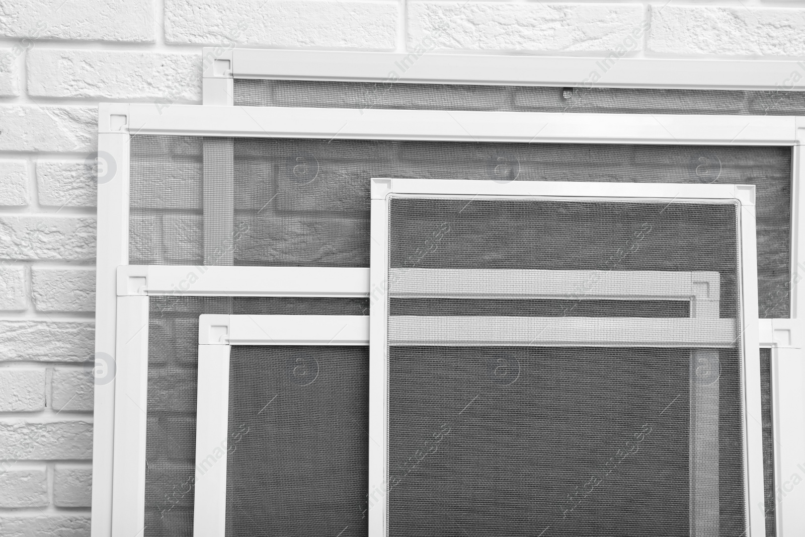 Set of window screens near white brick wall, closeup Photo of Set of window screens near white brick wall, closeup