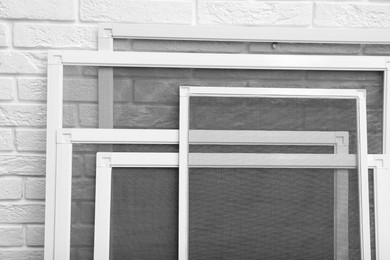 Set of window screens near white brick wall, closeup Photo of Set of window screens near white brick wall, closeup