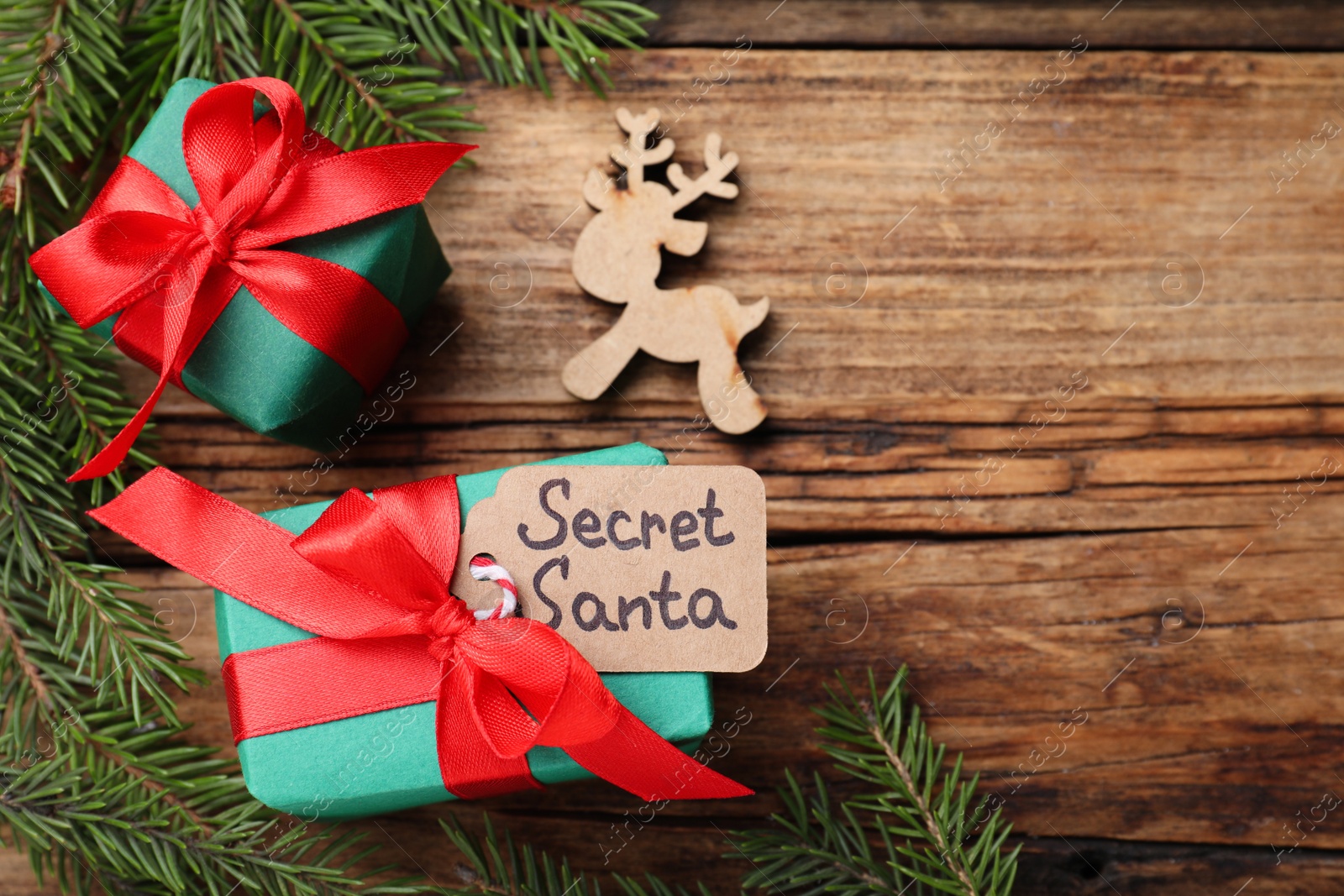 Flat lay composition with presents from secret Santa on wooden table, space for text Photo of Flat lay composition with presents from secret Santa on wooden table, space for text